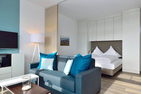 Aparthotel Anna Düne Aparthotel Anna Düne 2-29 Wangerooge - Wohn/ Essbereich mit Couch und Tisch