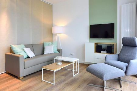 Aparthotel Anna Düne Aparthotel Anna Düne 2-32 Wangerooge - Wohn/ Essbereich mit Couch, Sessel und Fernseher