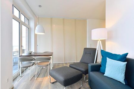 Aparthotel Anna Düne Aparthotel Anna Düne 2-33 Wangerooge - Wohn/ Essbereich mit Sessel und Esstisch