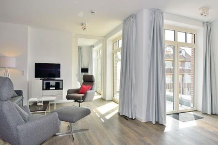 Aparthotel Anna Düne Aparthotel Anna Düne 2-39 Wangerooge - Wohn/ Essbereich mit Sessel, Tisch und Fernseher