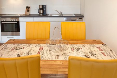 DünenResort Binz DünenResort Binz 417 Rügen - Wohn-Essbereich mit Esstisch, Sitzgelegenheit und Küchenzeile