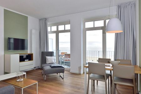 Aparthotel Anna Düne Aparthotel Anna Düne 1-23 Wangerooge - Wohn/ Essbereich mit Esstisch, Sessel und Fernseher