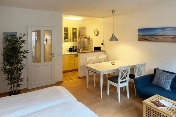 Wohnzimmer mit Schrankbett in der Ferienwohnung Strandlöper in Wittdün auf Amrum Huus Heverknob Ferienwohnung *Strandlöper*