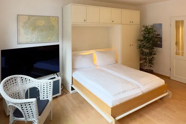 Wohnzimmer mit Schrankbett in der Ferienwohnung Strandlöper in Wittdün auf Amrum Huus Heverknob Ferienwohnung *Strandlöper*