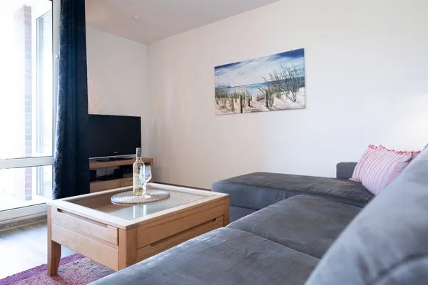 Wohnzimmer mit Couch, Fernseher und Sitzecke  Ferienwohnung "Mühlenteich App. 14"