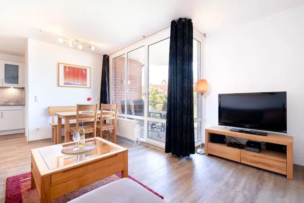 Wohnzimmer mit Couch, Fernseher und Sitzecke  Ferienwohnung "Mühlenteich App. 14"