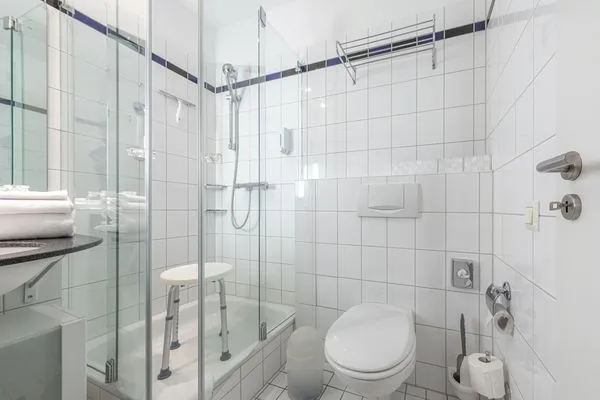 Ferienwohnung Bernstein Zingst – Modernes Badezimmer mit bodengleicher Dusche, WC und hellen Fliesen  Bernstein