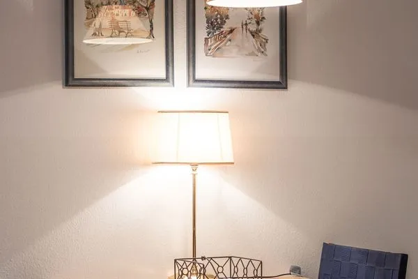 Ferienwohnung Bernstein Zingst – Stilvoller Essbereich mit Wandbildern und warm beleuchteter Tischlampe  Bernstein