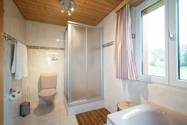 Bathroom with shower and bathtub  Ferienhaus Bergblick