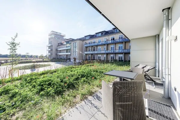 Ferienapartment Ostseestuv Wustrow – Sonnige Terrasse mit gemütlicher Sitzlounge und Blick ins Grüne  Ostseestuv