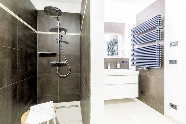 Ferienwohnung First Garden View Wustrow – Elegantes Badezimmer mit ebenerdiger Dusche und hochwertigen Armaturen  First Garden View