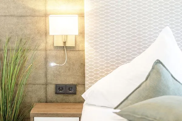 Ferienwohnung First Garden View Wustrow – detailverliebtes Schlafzimmer mit stilvoller Wandlampen  First Garden View