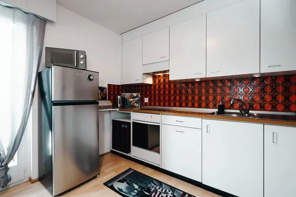Kitchen with a big refrigerator and a microwave  Apartment Panoramablick