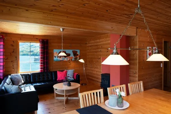Wohnzimmer mit Holzofen und gemütlichem Ledersofa  Fjordhytte-4