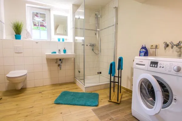 Badezimmer mit Dusche und Waschmaschine  Ferienwohnung im Landmannsheim