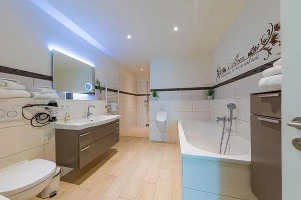 ChatGPT:  Ferienwohnung Garzini Hafenresidenz Waren (Müritz) – Großzügiges Badezimmer mit Badewanne, ebenerdiger Dusche  Garzini