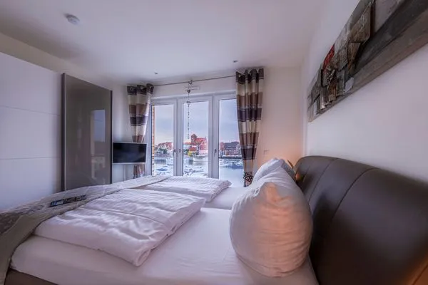 ChatGPT:  Ferienwohnung Garzini Hafenresidenz Waren (Müritz) – Schlafzimmer mit komfortablem Doppelbett  Garzini