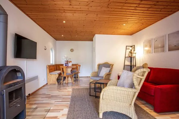 Ferienhaus MöwenKieker offener Wohnbereich mit Sitzecke und Kamin  MöwenKieker