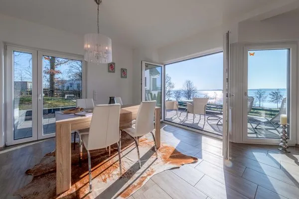 Ferienhaus SchönSicht Essbereich mit Zugang zur Terasse und Blick auf das Wasser  SchönSicht