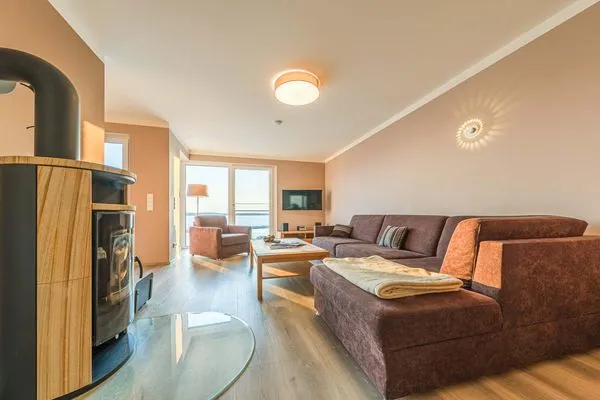 Ferienwohnung Auszeit Hafenresidenz Waren (Müritz) - Wohnzimmer mit Kamin und Sofa  Auszeit