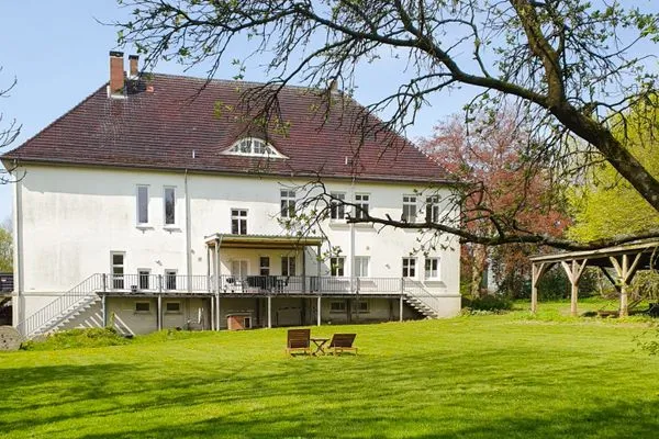 Rückseite des Hauses mit Garten und Terrasse  Ferienwohnung Gut Hardesby