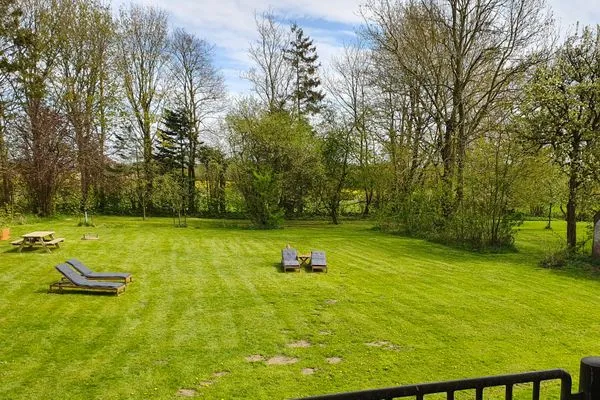 Großer, eingezäunter Gartenbereich mit Liegestühlen, Sandkiste und Feuerstelle  Ferienwohnung Gut Hardesby