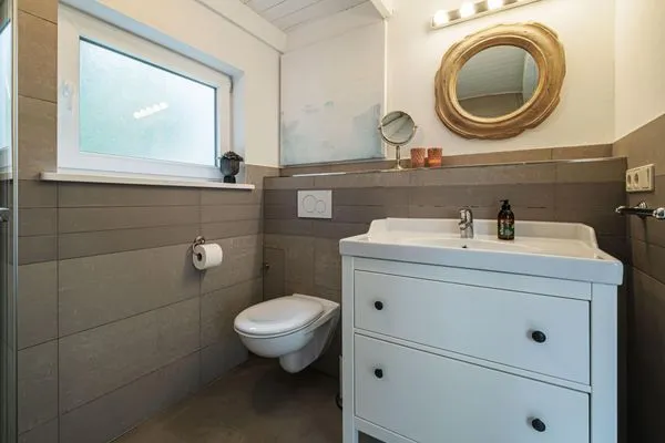 Badezimmer mit Fenster, Waschtisch, WC, Fußbodenheizung und Dusche  Strandhaus am Mühlendamm