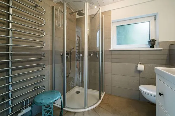 Badezimmer mit Fenster, Waschtisch, WC, Fußbodenheizung und Dusche  Strandhaus am Mühlendamm