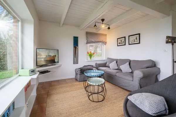 Gemütliches Wohnzimmer mit Ofen und Meerblick  Strandhaus am Mühlendamm