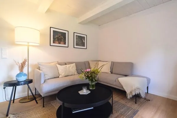 Wohnzimmer mit gemütlicher Eck-Couch  Reetdachkate Fuchsgraben