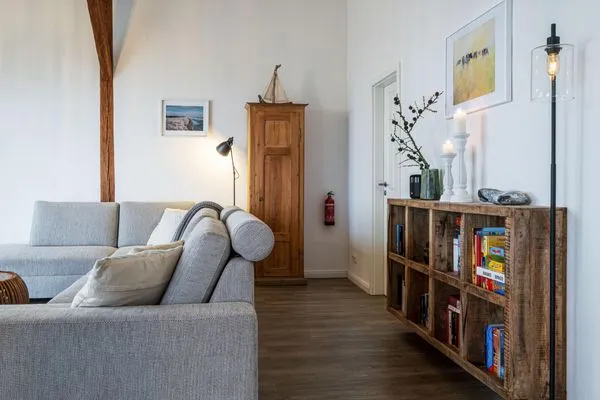 Offenes Wohnzimmer mit Couch, Meerblick, Ofen und Essbereich  Westscheune am Mühlendamm