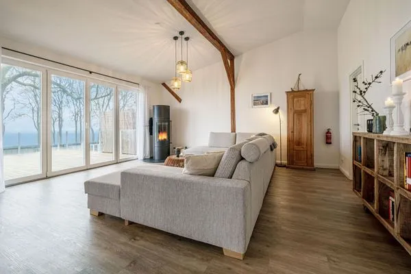 Offenes Wohnzimmer mit Couch, Meerblick, Ofen und Essbereich  Westscheune am Mühlendamm