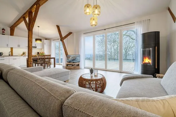 Offenes Wohnzimmer mit Couch, Meerblick, Ofen und Essbereich  Westscheune am Mühlendamm