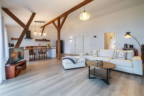 Wohnbereich mit Meerblick, Couch, Ofen und Küche  Ostscheune am Mühlendamm