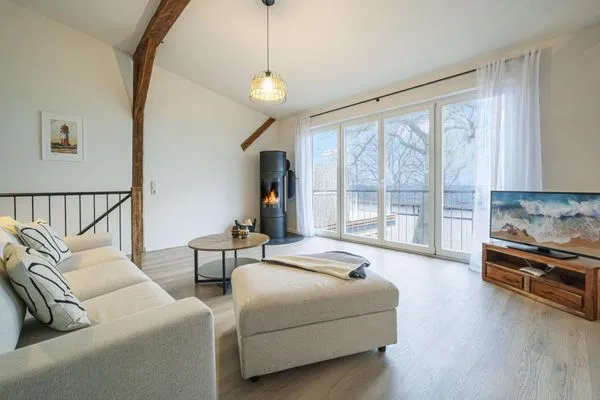 Wohnbereich mit Meerblick, Couch, Ofen und Küche  Ostscheune am Mühlendamm