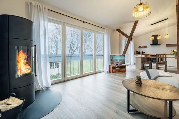 Wohnbereich mit Meerblick, Couch, Ofen und Küche  Ostscheune am Mühlendamm
