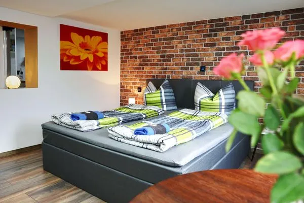 Gemütliche Sitzecke im Schlaf- und Wohnbereich mit Blick auf das Bett  Ferienapartment Zur guten Quelle