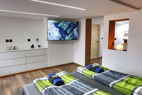 Blick übers Bett in Richtung TV  Ferienapartment Zur guten Quelle