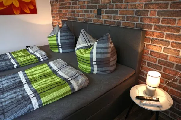 Bett und Ablage mit Nachttischlampe (rechts)  Ferienapartment Zur guten Quelle