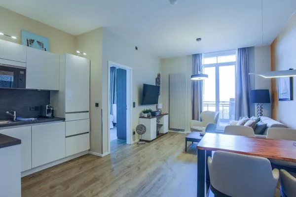 Ferienwohnung First Garden View Wustrow – Heller Wohnbereich mit moderner Küche und stilvoller Einrichtung  First Garden View