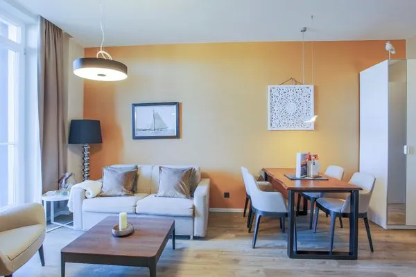 Ferienwohnung First Garden View Wustrow – helles, modernes Wohnzimmer mit gemütlicher Sitzecke  First Garden View