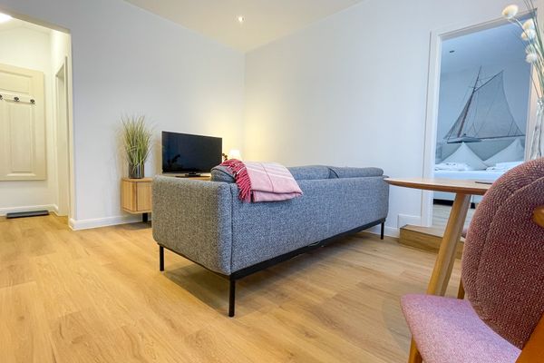  Haus Derk Juist - Wohnung 12 Borkum - Wohnzimmer mit Blick auf Sofa, Sideboard und TV
