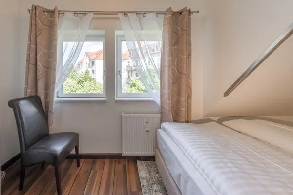 Ferienwohnung Seeperle Schlafzimmer mit Fenster und Stuhl  Seeperle