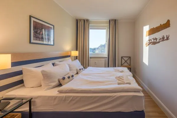 Ferienwohnung Kranichtanz Aparthotel Zingst - helles Schlafzimmer mit gemütlichem Doppelbett  Kranichtanz