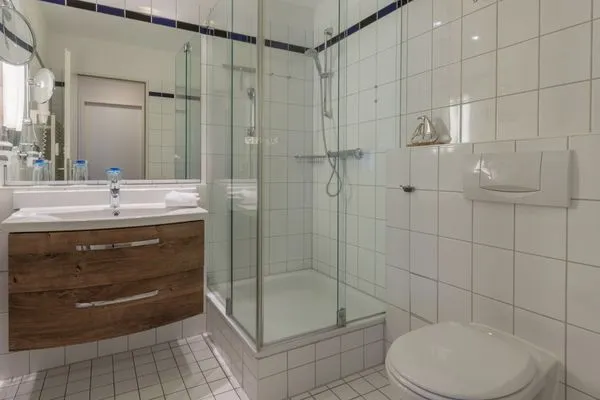 Ferienwohnung Kranichtanz Aparthotel Zingst - Badezimmer mit Waschbecken, Toilette und Glasdusche  Kranichtanz