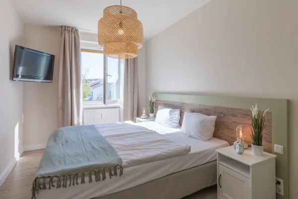 Ferienwohnung Küstenglück Aparthotel Zingst - Schlafzimmer mit Doppelbett und TV  Küstenglück