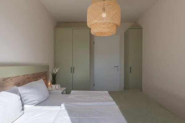 Ferienwohnung Küstenglück Aparthotel Zingst - Blick ins Schlafzimmer mit Doppelbett und Kleiderschrank  Küstenglück