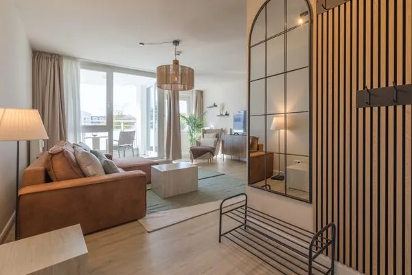 Ferienwohnung Küstenglück Aparthotel Zingst - Blick in das offene Wohnzimmer mit Balkon  Küstenglück