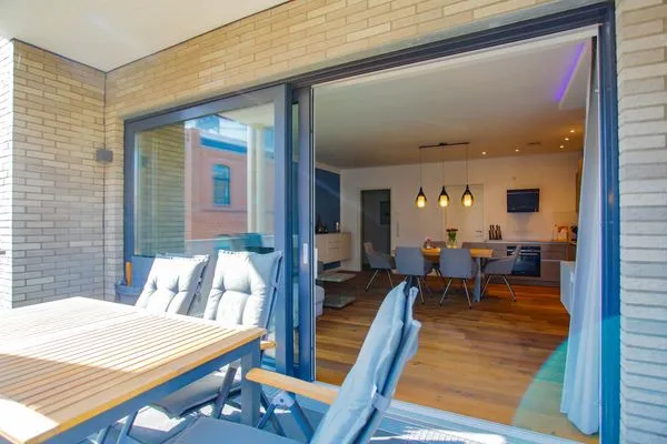 Ferienwohnung Inselsuite Malchow Balkon in der Sonneund Blick in den Wohnbereich  Inselsuite