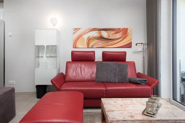 Ferienwohnung Anastasia Waren Wohnzimmer mit rotem Sofa  Anastasia